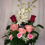 A flower arrangement with roses and orchids.