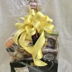 A gift basket with a teddy bear and a yellow ribbon.